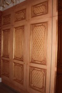 softly aged cupboards with gold  leaf motif and detail