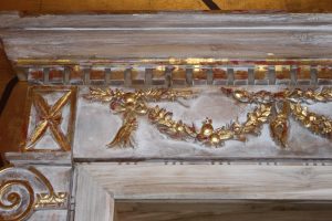 detail of distressed whitewashed doors with gold leaf